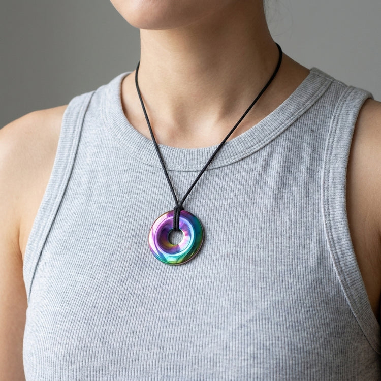 Regenbogen-Hämatit Donut | 40 mm Anhänger + Baumwollband — Lifestyle-Tragebild