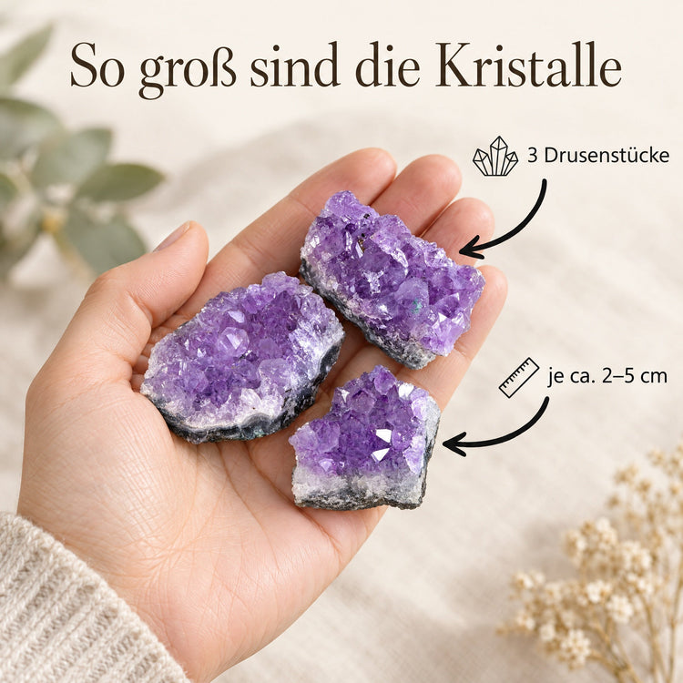 Drei Amethyst-Drusenstücke in der Hand, je ca. 2–5 cm