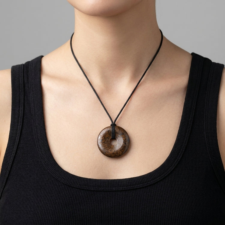 Bronzit Donut | 40 mm Anhänger + Baumwollband — Lifestyle-Tragebild