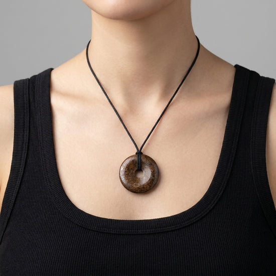 Bronzit Donut | 40 mm Anhänger + Baumwollband — Lifestyle-Tragebild